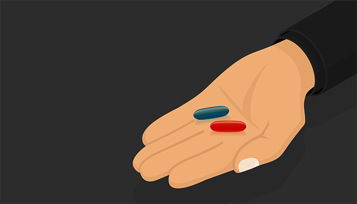 hand holding a red and a blue pill